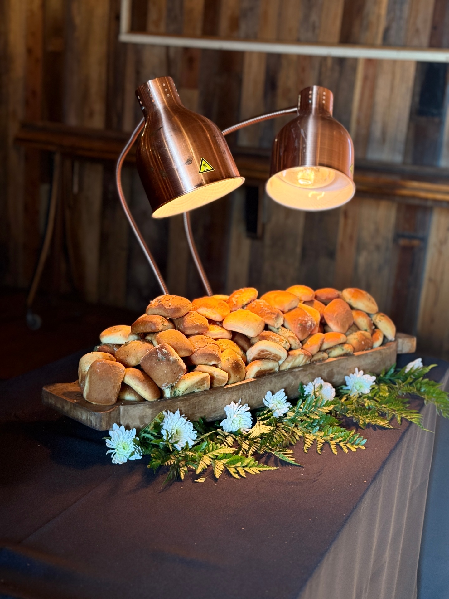 Fresh-baked rolls under copper warming lamps