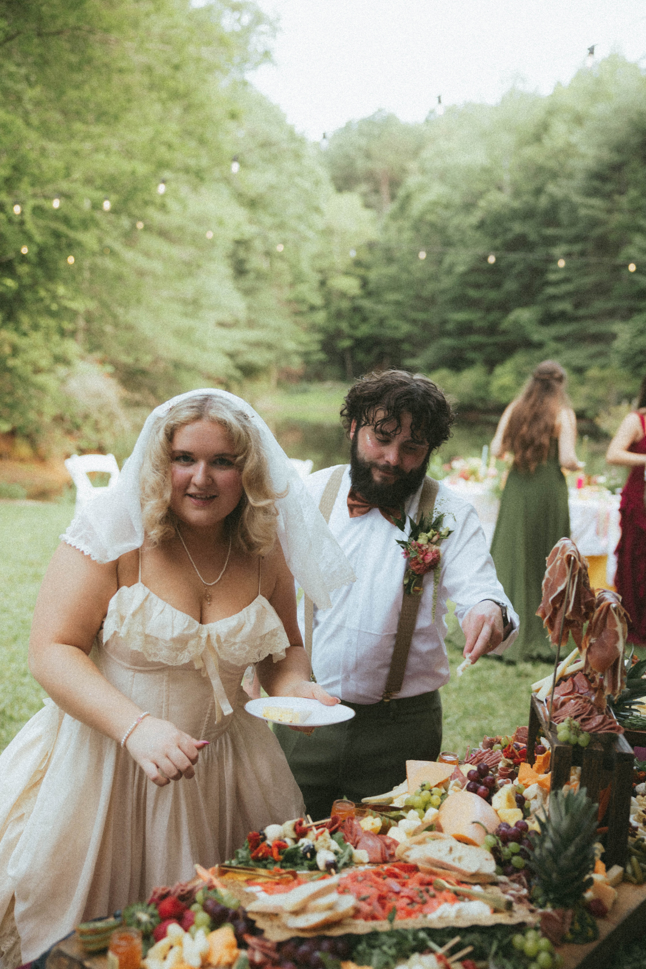 Bride and groom at a White Wine & Butter catered graze table at an outdoor wedding near Greer SC
